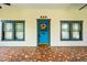 Charming blue front door framed by windows, complemented by a patterned porch and decorative accents at 515 Frank Lloyd Wright Way, Lakeland, FL 33803