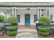 Inviting front porch with meticulously trimmed shrubs and a charming blue door at 515 Frank Lloyd Wright Way, Lakeland, FL 33803