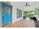 Covered front porch with detailed tilework, ceiling fan, and a welcoming blue door at 515 Frank Lloyd Wright Way, Lakeland, FL 33803