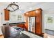 Kitchen with stainless steel appliances, granite countertops, and pot rack hanging above island at 515 Frank Lloyd Wright Way, Lakeland, FL 33803