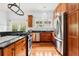 Kitchen featuring stainless steel appliances, wooden cabinets, granite countertops, and an overhead pot rack at 515 Frank Lloyd Wright Way, Lakeland, FL 33803