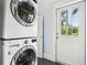 A laundry room with stacked washer and dryer at 515 Frank Lloyd Wright Way, Lakeland, FL 33803