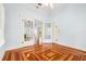 Spacious living room with patterned wood flooring, high ceilings, and elegant glass doors at 515 Frank Lloyd Wright Way, Lakeland, FL 33803