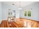 Open layout with patterned hardwood floors, chandelier, large windows, and direct access into a connected room at 515 Frank Lloyd Wright Way, Lakeland, FL 33803