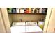 Functional laundry area with a washer, dryer, and storage shelves, providing ample space for laundry essentials at 472 Blue Heron Cir, River Ranch, FL 33867