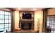 Cozy living room with stone fireplace, mantle, and large windows with natural light at 472 Blue Heron Cir, River Ranch, FL 33867