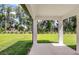 Covered back patio offering serene views of the lush green backyard and surrounding trees at 8249 Sw 52Nd Lane Rd, Ocala, FL 34481