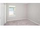 This cozy bedroom has neutral walls and carpet, with a window allowing ample light at 5408 Sw 85Th Avenue Rd, Ocala, FL 34481