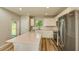 Open kitchen with white cabinets, quartz countertops, stainless steel appliances, and wood-look flooring at 5433 Sw 82Nd Ter, Ocala, FL 34481