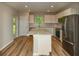 Lovely kitchen with white cabinets, quartz countertops, stainless steel appliances, and center island with wood-look flooring at 5433 Sw 82Nd Ter, Ocala, FL 34481