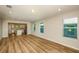 Open-concept living room featuring wood-look flooring and ample natural light from the multiple windows at 5433 Sw 82Nd Ter, Ocala, FL 34481