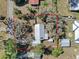 Aerial view of home showcasing metal roof, mature trees, detached garage, fully fenced yard, and a storage shed at 7013 Beverly Rd, Lakeland, FL 33813