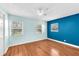 Bright bedroom featuring hardwood floors, neutral paint, and bright blue accent wall at 7013 Beverly Rd, Lakeland, FL 33813
