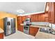 Well-lit kitchen features stainless steel appliances, wood cabinets and tiled backsplash at 7013 Beverly Rd, Lakeland, FL 33813
