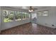 Sunroom featuring tile floor, white paneling, windows, and a ceiling fan with lights at 7013 Beverly Rd, Lakeland, FL 33813