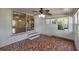 Bright sunroom featuring tile flooring, white paneling, windows, and a ceiling fan with lights at 7013 Beverly Rd, Lakeland, FL 33813