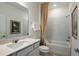 Well-lit bathroom features marble countertop, neutral colored shower curtain, and white subway tile at 8207 Sw 52Nd Lane Rd, Ocala, FL 34481
