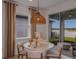Dining area with a modern light fixture, round table, and chairs with sliding glass doors leading outside at 8207 Sw 52Nd Lane Rd, Ocala, FL 34481