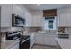 Well-lit kitchen with stainless steel appliances, white cabinetry, a window and tiled backsplash at 8207 Sw 52Nd Lane Rd, Ocala, FL 34481