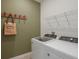 Efficient laundry room equipped with modern washer and dryer, complete with shelving and accents at 8207 Sw 52Nd Lane Rd, Ocala, FL 34481