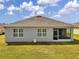 Exterior view of home featuring a screened-in porch and large windows, overlooking the grassy backyard at 1780 Jackson Oaks Dr, Bartow, FL 33830