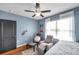 Bedroom with light blue walls, wood flooring, ceiling fan, and a comfortable recliner chair at 1780 Jackson Oaks Dr, Bartow, FL 33830