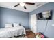 Cozy bedroom features a ceiling fan, TV, hardwood floors, and blue walls at 1780 Jackson Oaks Dr, Bartow, FL 33830