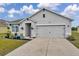 Charming single-Gathering home featuring a well-manicured lawn, flower beds, and a gray two-car garage at 1780 Jackson Oaks Dr, Bartow, FL 33830