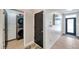 Hallway with tile floors, black doors, laundry closet with stacked washer/dryer and access to front door at 1780 Jackson Oaks Dr, Bartow, FL 33830
