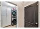 Compact laundry room with stacked washer/dryer units and white cabinets for extra storage space at 1780 Jackson Oaks Dr, Bartow, FL 33830