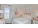 Cozy pink bedroom featuring a bed with decorative pillows and neutral curtains at 2418 Slippery Rock St, Auburndale, FL 33823
