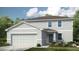 Charming two-story home with a two-car garage, landscaped yard, and light grey siding at 2418 Slippery Rock St, Auburndale, FL 33823