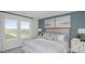 Tranquil main bedroom with neutral decor, two windows, and blue accent wall with artwork at 2418 Slippery Rock St, Auburndale, FL 33823