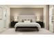 Bedroom with gray walls, king bed, decorative bench, and matching nightstands with lamps and neutral decor at 5031 Barnet Dr, Davenport, FL 33837