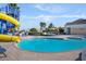 A slide at the pool surrounded by blue lounge chairs and palm trees perfect for relaxation and summer fun at 5107 Bridgehaven Rd, Davenport, FL 33837