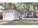 Charming single-story home with a well-maintained lawn, a one-car garage, and mature trees at 645 W Winter Park St, Orlando, FL 32804