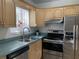 Kitchen featuring stainless steel appliances, light wood cabinets, and a double basin sink at 645 W Winter Park St, Orlando, FL 32804