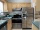 Kitchen featuring stainless steel appliances, light wood cabinets, and a double basin sink at 645 W Winter Park St, Orlando, FL 32804