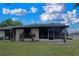 View of home's screened in lanai and green backyard, perfect for relaxing and entertaining at 23 Buck Cir, Haines City, FL 33844