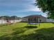 Spacious backyard features a white vinyl fence, playset, trampoline, and lush green grass at 6272 Cornerstone Dr, Lakeland, FL 33813