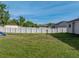 Spacious backyard with green grass, a disc golf basket, and a white vinyl perimeter fence at 6272 Cornerstone Dr, Lakeland, FL 33813