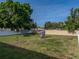 Large backyard featuring green grass, a playset with slide, trampoline, and white vinyl perimeter fence at 6272 Cornerstone Dr, Lakeland, FL 33813
