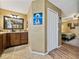 Bathroom features vanity with dark wood cabinets, modern lighting fixture, and shower with glass doors at 6272 Cornerstone Dr, Lakeland, FL 33813