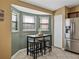 Eat-in kitchen featuring stainless steel refrigerator, a table, and three stools by large bright windows at 6272 Cornerstone Dr, Lakeland, FL 33813