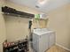 Functional laundry room features a washer, dryer, overhead storage, and space for organizing laundry supplies at 6272 Cornerstone Dr, Lakeland, FL 33813