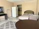 Studio bedroom featuring a comfortable bed and small kitchen area with a refrigerator at 7900 S Orange Blossom Trl # 1099, Orlando, FL 32809