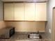 Functional kitchenette area with compact cabinets, microwave, and stainless steel sink at 7900 S Orange Blossom Trl # 1099, Orlando, FL 32809