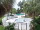 Community pool area with a jacuzzi surrounded by white picket fencing and palm trees at 7900 S Orange Blossom Trl # 1099, Orlando, FL 32809