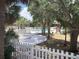 Community pool and jacuzzi with green spaces, framed by a white picket fence and lush palm trees at 7900 S Orange Blossom Trl # 1099, Orlando, FL 32809