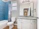 A modern bathroom with a blue tiled shower, vanity, and toilet at 917 Shawna Shrs, Haines City, FL 33844